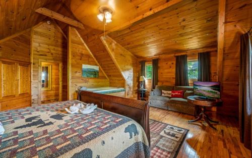 a bedroom in a cabin with a bed and a couch at Beary Inn and Sweets in Pigeon Forge