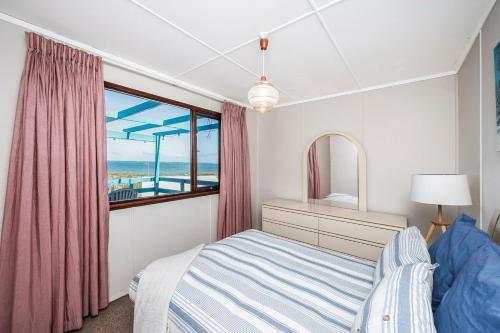 a bedroom with a bed and a window with a view of the ocean at Blue View - UNINTERRUPTED OCEAN VIEWS FOR MILES in Guilderton