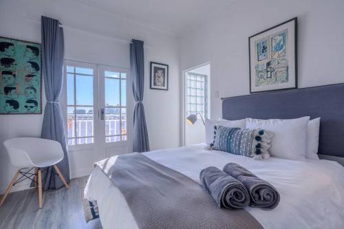 a bedroom with a white bed with towels on it at The Dolls House in Cape Town
