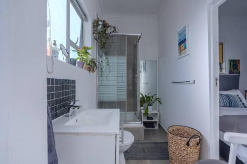a white bathroom with a sink and a toilet at The Dolls House in Cape Town