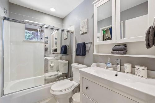 a white bathroom with a toilet and a sink at Adventure Awaits - Pets - Hot tub - Fire pit in Mevers