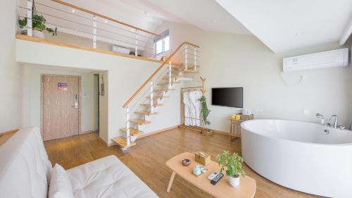 a living room with a bath tub and a staircase at Dashe Yuanye Boutique Homestay in Xitang