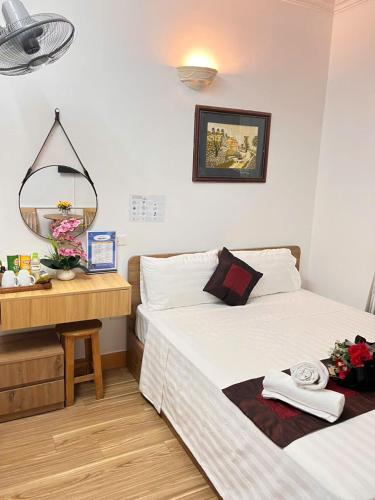 a bedroom with two beds and a desk with a mirror at Okaeri Homestay in Hanoi
