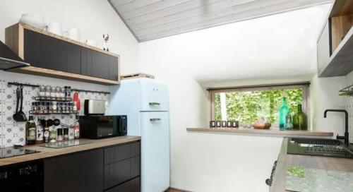a kitchen with a white refrigerator and a window at Inn Serendipity Eesti in Jaagupi