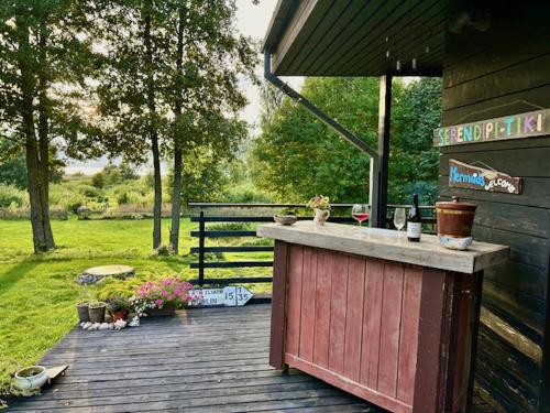 a wooden deck with a bar on the side of a house at Inn Serendipity Eesti in Jaagupi
