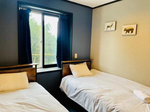 Postel nebo postele na pokoji v ubytování Ember Lodge - Hakuba