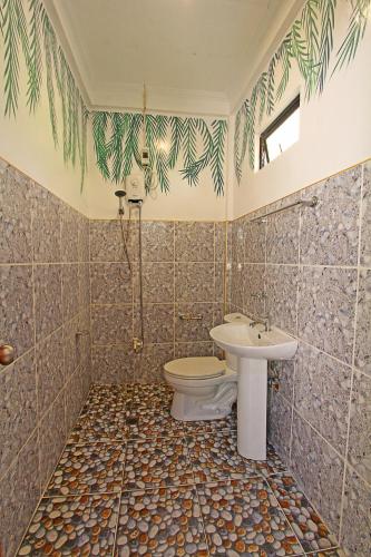 a bathroom with a toilet and a sink at Villa Consolacion Resort in General Luna