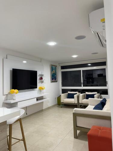 a living room with a tv and a couch at Radiante departamento frente al mar in Playas