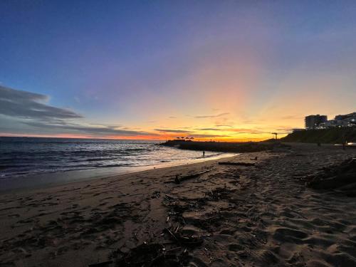 a sunset on a beach with the ocean at Radiante departamento frente al mar in Playas