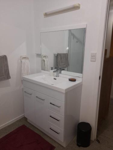 a white bathroom with a sink and a mirror at TuiGlen in Dinsdale