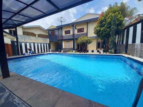 een groot blauw zwembad voor een gebouw bij Villa Putih in Cisarua