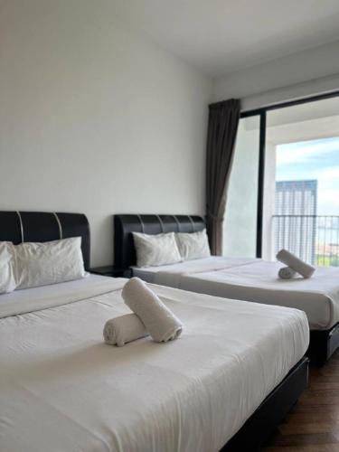 two beds in a hotel room with a window at The Landmark Comfort Relax Spacious Sea View By IZ in Tanjong Tokong