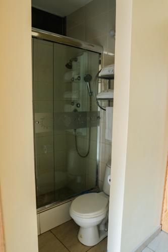 a bathroom with a toilet and a shower at TruGarden Hotel Trujillo in Trujillo
