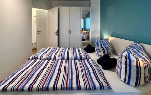 ein Schlafzimmer mit einem großen Bett mit gestreifter Bettwäsche in der Unterkunft Residenz am Yachthafen, Whg 4 in Grömitz