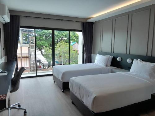 甘烹碧J2 Hotel的有两张床和一扇大窗户的酒店房间