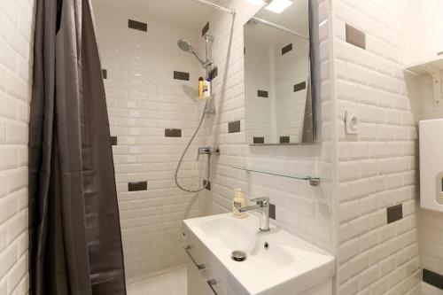 a white bathroom with a sink and a shower at Renovated Studio for 2 in Paris