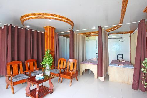 a room with two beds and a table and chairs at Villa Consolacion Resort in General Luna