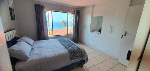 a bedroom with a bed with a view of the ocean at Die Ankers - Apartment 12 in Margate