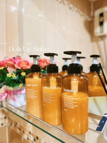 a group of four bottles of soap on a shelf at 2BR Holiday Suite Hat Yai in Hat Yai