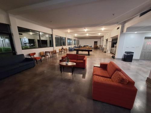 a living room with couches and a table and chairs at The Hotel Orange in Orange