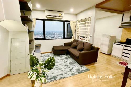 a living room with a couch and a large window at 2BR Holiday Suite Hat Yai in Hat Yai