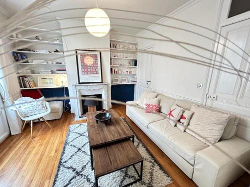 un salon avec un canapé blanc et une table dans l'établissement Clou dans le fer hyper centre immeuble luxueux, à Reims