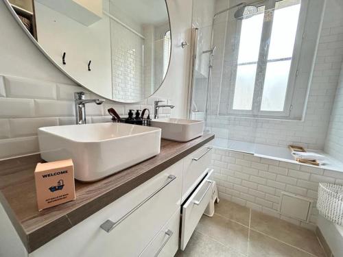 une salle de bain blanche avec un lavabo et un miroir dans l'établissement Clou dans le fer hyper centre immeuble luxueux, à Reims