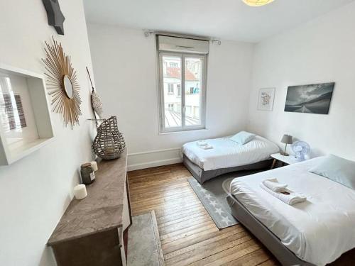 Cette chambre blanche comprend deux lits et un canapé. dans l'établissement Clou dans le fer hyper centre immeuble luxueux, à Reims