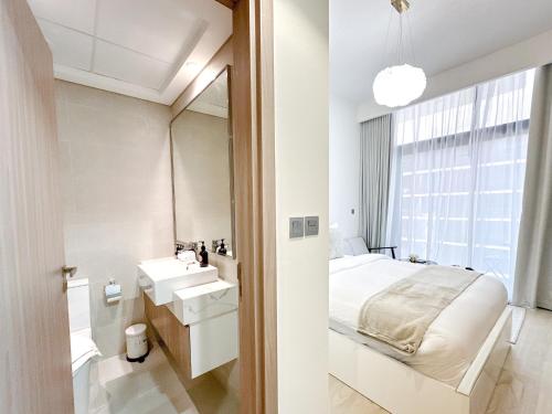 a bedroom with a bed and a sink and a mirror at EasyGo - Unbeatable Deals on Urban Rentals in Riviera 16 in Dubai