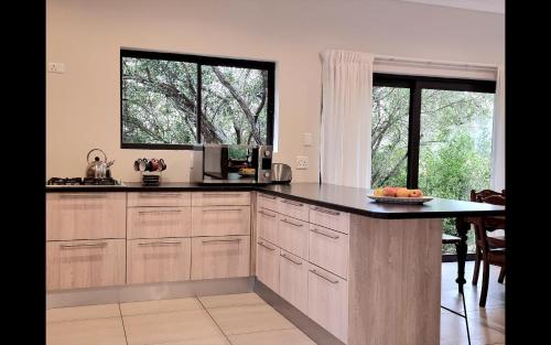 a kitchen with a counter and a large window at Alkantmooi Private Nature Reserve - Keurkloof & Keurbos 93 in Plettenberg Bay
