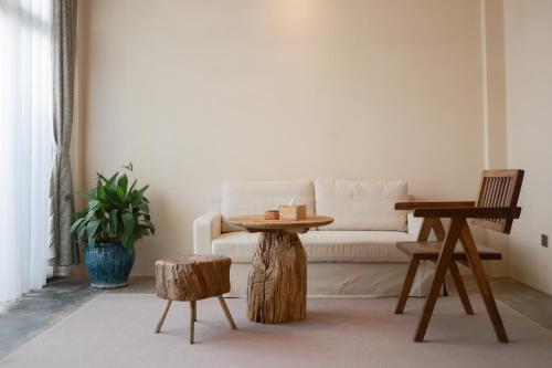 ein Wohnzimmer mit einer Couch und zwei Tischen in der Unterkunft YSN Hill Breeze Retreat 云山南 玉龙雪山园林观景酒店 丽江古城束河白沙古镇店 in Lijiang
