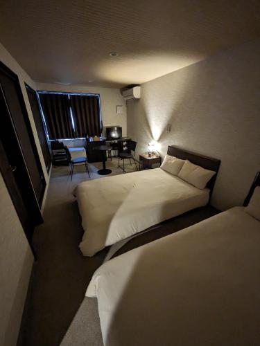 a bedroom with two beds and a desk in a room at NARITA HOTEL KAKUREGA - Vacation STAY 69221v in Narita