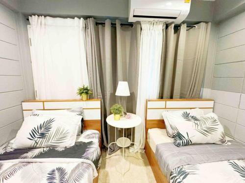 two beds in a room with a table and a window at 5BRHouse City centre Silom 3min to BTS Saint Louis in Bangkok