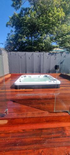 a bath tub sitting on top of a wooden floor at Vitamin Sea Beach House with outdoor Spa in Rosebud