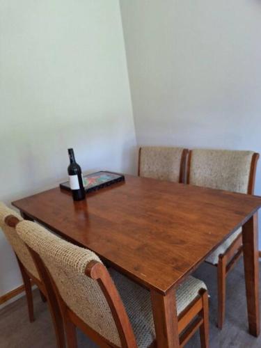 a wooden table with a bottle of wine on it at Comfy 3 bed house in Ulladulla in Ulladulla