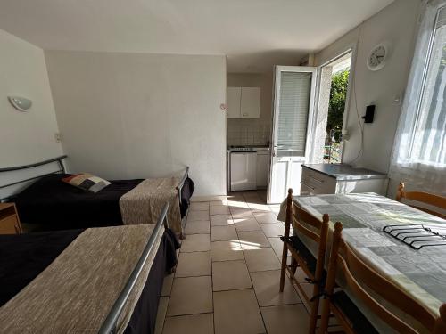 une petite chambre avec deux lits et une cuisine dans l'établissement Studio cosy avec balcon, jardin, WIFI et stationnement près des Thermes - FR-1-541-114, à La Roche-Posay