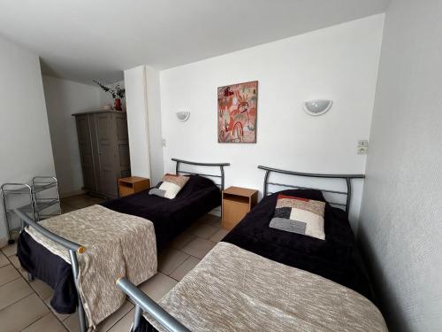 une chambre avec deux lits et une table dans l'établissement Studio cosy avec balcon, jardin, WIFI et stationnement près des Thermes - FR-1-541-114, à La Roche-Posay