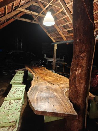 a large wooden bench sitting in a room with a tree at Jungle stay by Bilwa Estate in SanivÄrsante