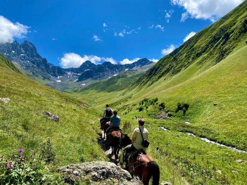 a group of people riding horses down a hill at Rakursi in Jut'a