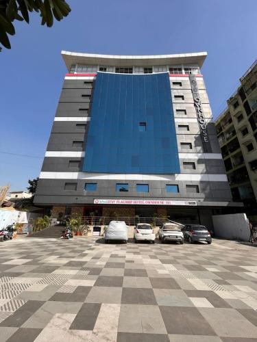 a large building with cars parked in a parking lot at SwagStay Hotel OwnHouse 181 Nagpur in Nagpur