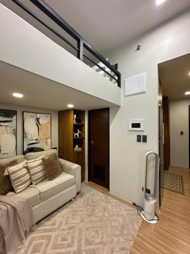 a living room with a couch and a loft at Studio unit loft bed st dominique in Iloilo City