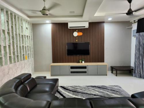 a living room with a couch and a television at Shakira homestay in Kota Bharu