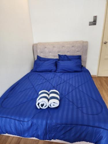 two pairs of slippers on a blue bed at Shakira homestay in Kota Bharu