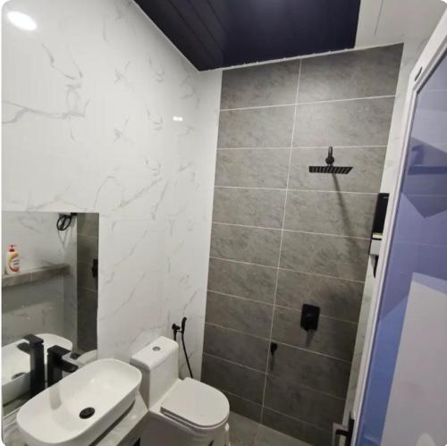 a bathroom with a toilet and a sink and a shower at Shakira homestay in Kota Bharu