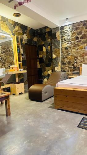 a bedroom with a bed and a stone wall at The Symbol of Ella in Ella