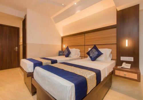 a hotel room with two beds and a telephone at Hotel Mourya Residency in Navi Mumbai