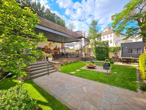 a backyard with a patio with a lawn at Boutique Hotel Marielle in Bad Münstereifel