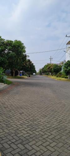 an empty street with trees on the side of the road at Nita's Sweet Home Tidar Malang Close to Soehat in Kasri