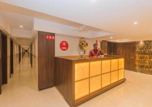 a man standing at a counter in a room at Hotel Mourya Residency in Navi Mumbai