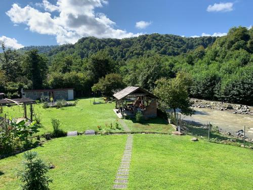 a garden with a gazebo in the grass at River house in Ozurgetʼi